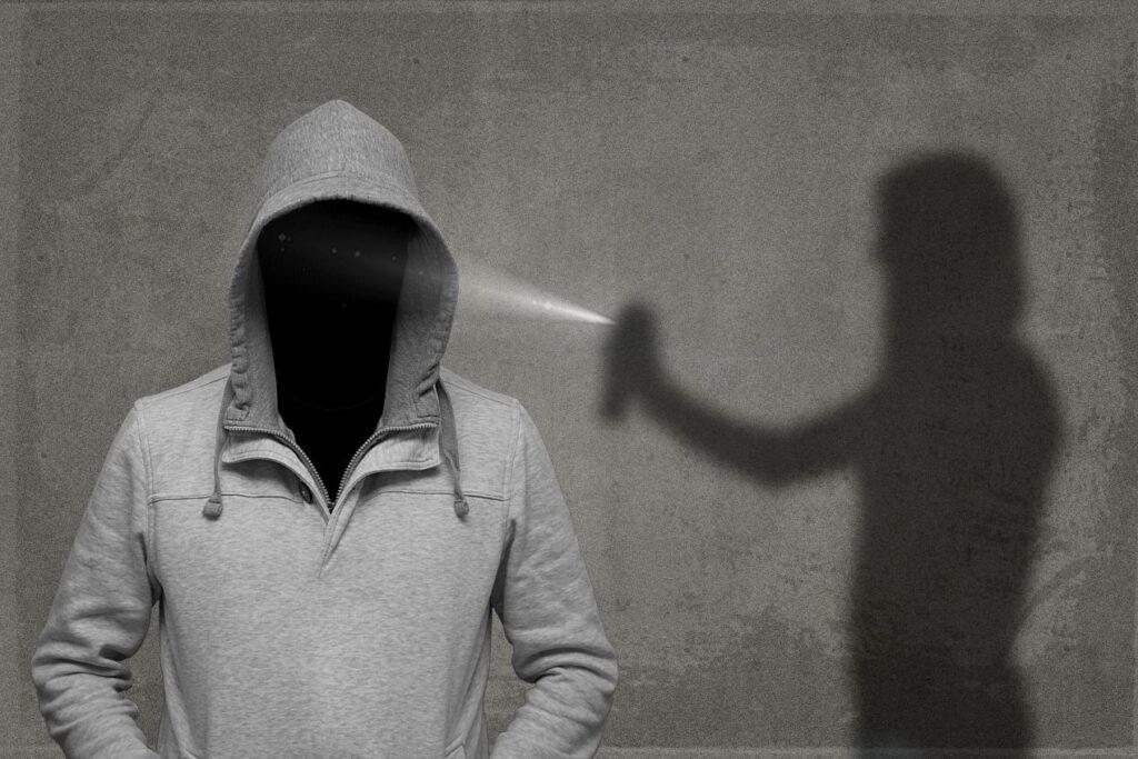 Schatten zeigt Person mit Pfefferspray zur Abwehr einer Bedrohung als Alternative zur Schreckschusspistole Berlin